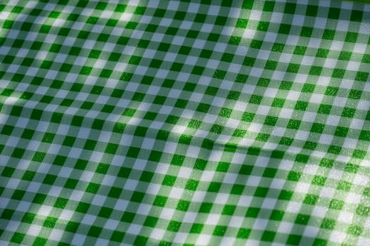 Close-up of green and white checkered fabric, ideal for picnic table setting.