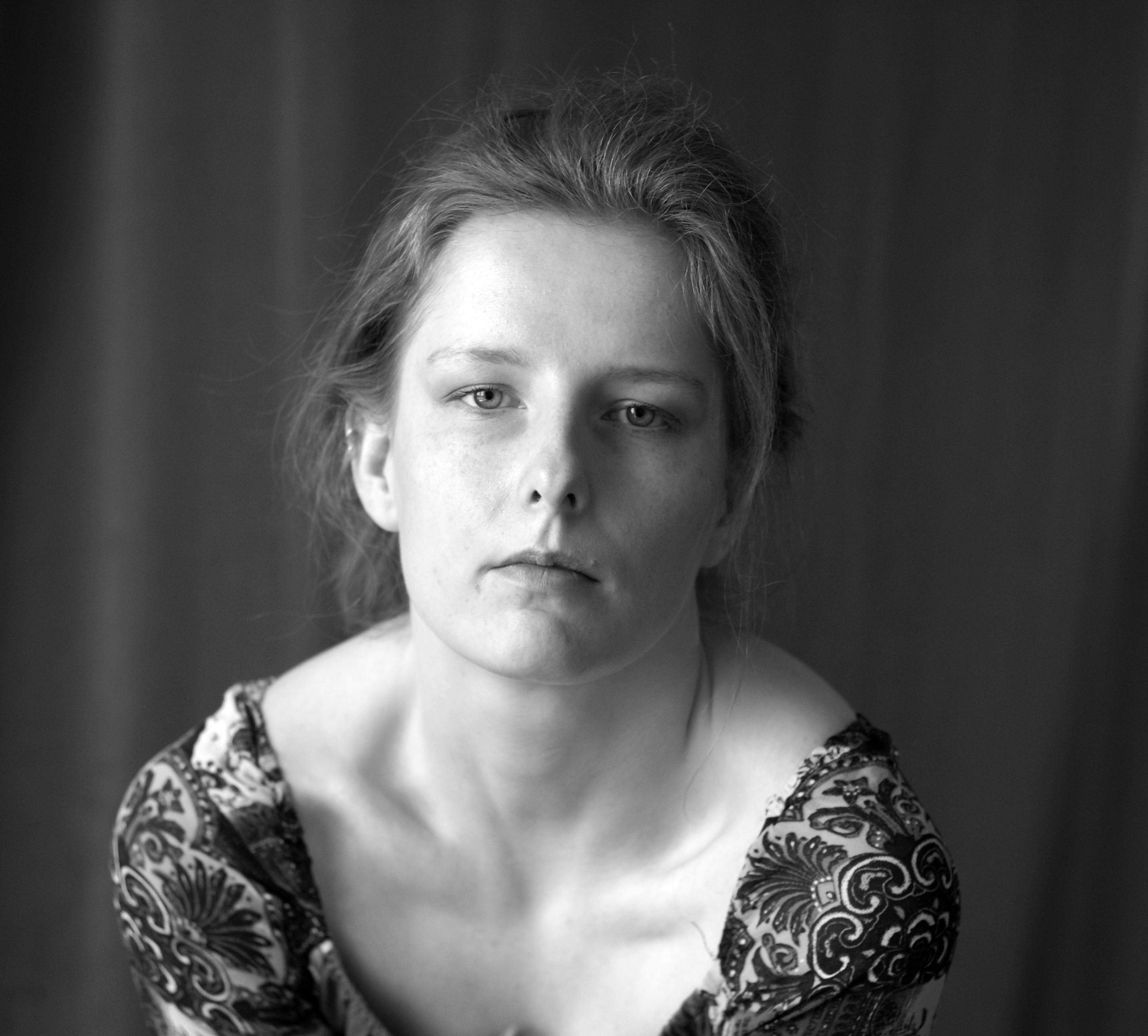 Artistic black and white portrait capturing a pensive woman's expression.