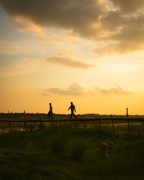 Sunset Silhouette of Two People on Bridge · Free Stock Photo