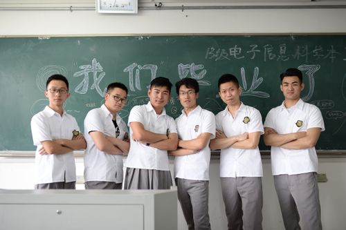 Free Group of male students standing confidently in classroom setting with chalkboard background. Stock Photo