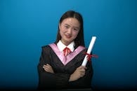 Smiling Graduate Holding Diploma on Blue Background