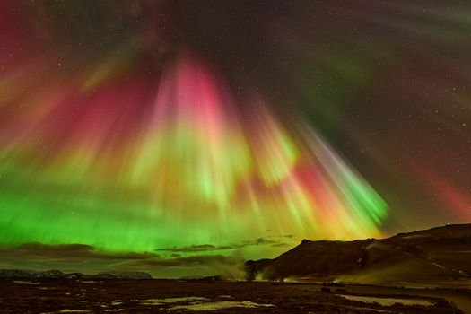 Vivid aurora borealis illuminating the Icelandic night sky at Reykjahlíð.