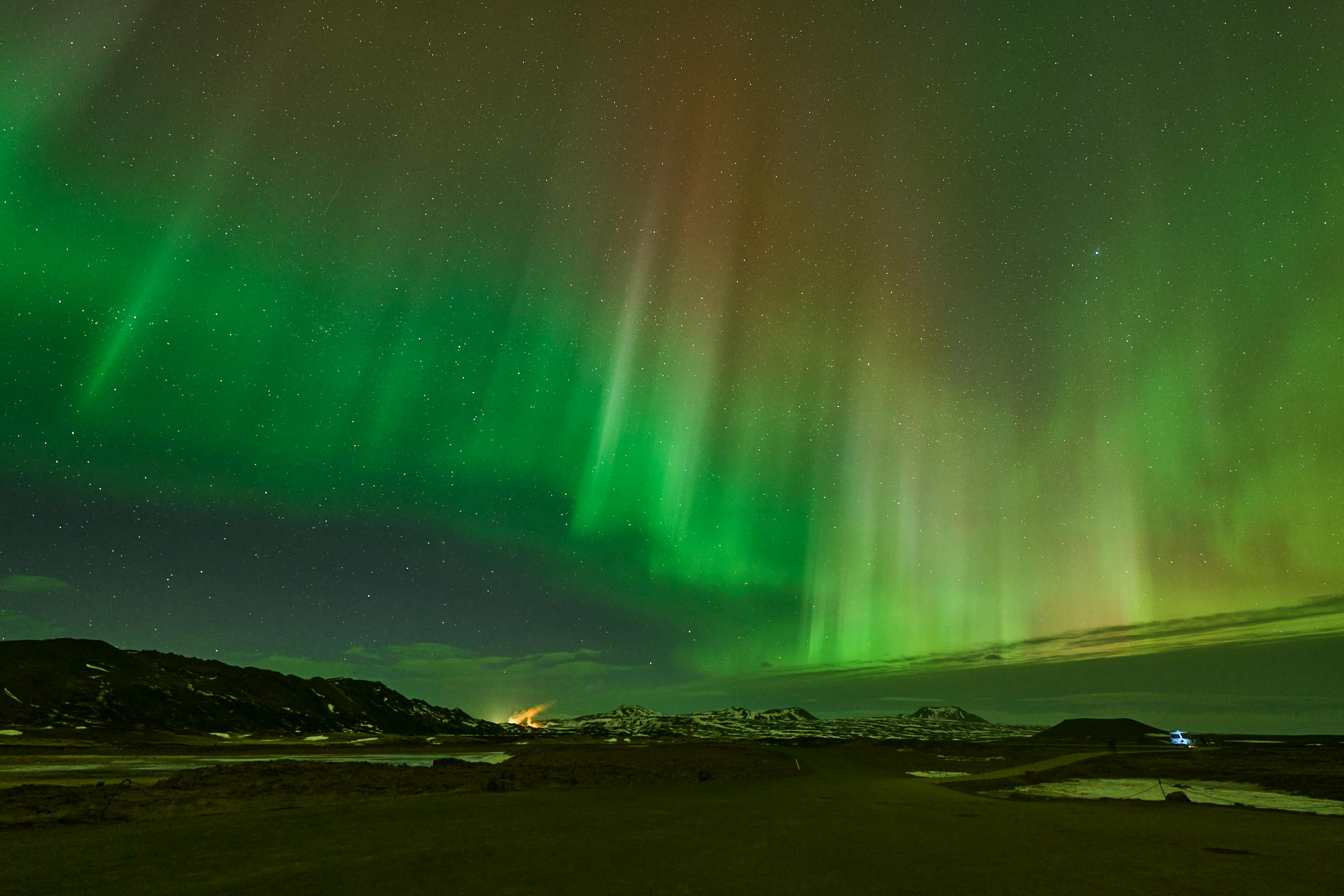 Capture of the vibrant aurora borealis illuminating the night sky in Reykjahlíð, Iceland.