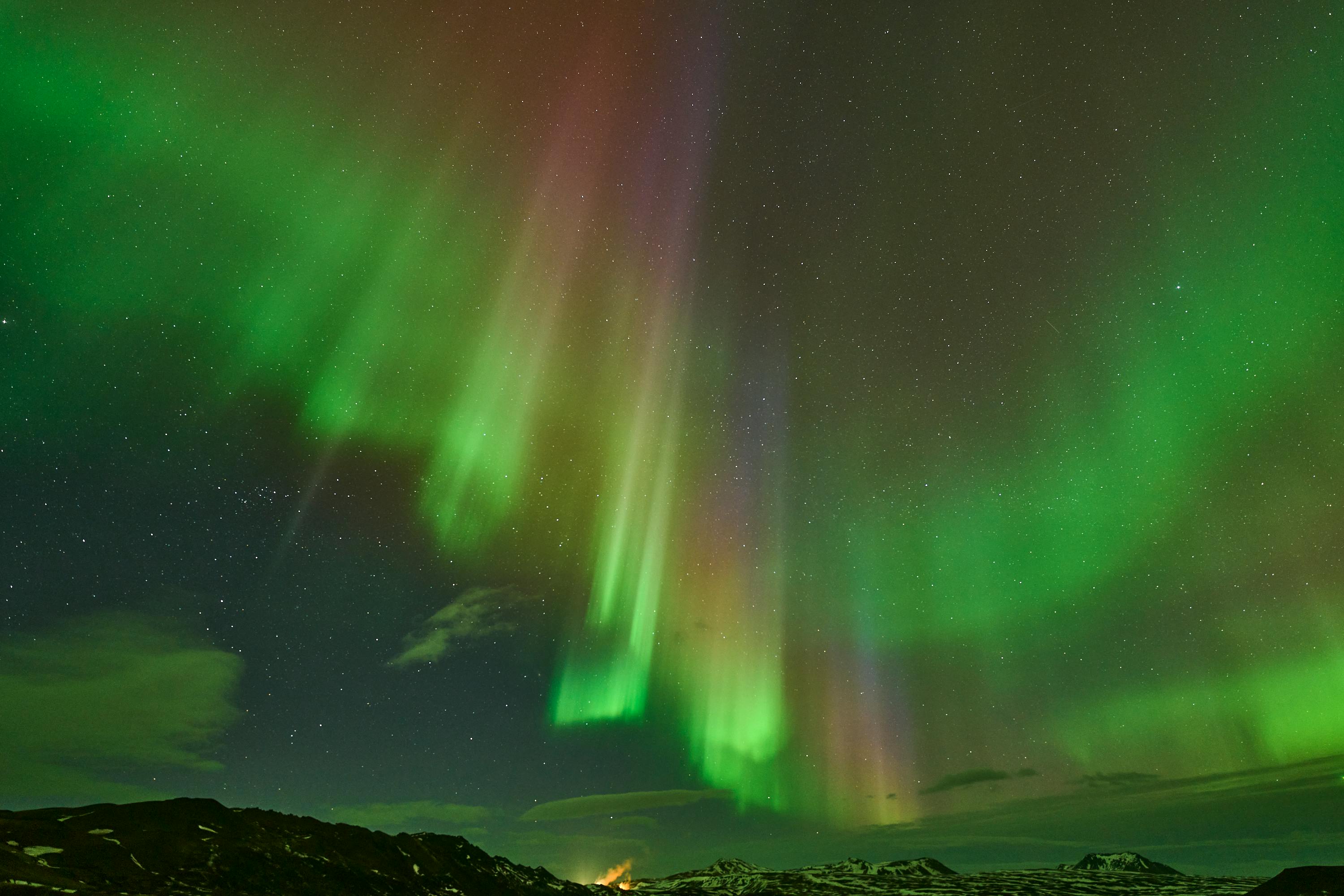 Northern lights dancing over snowy Icelandic landscape in winter