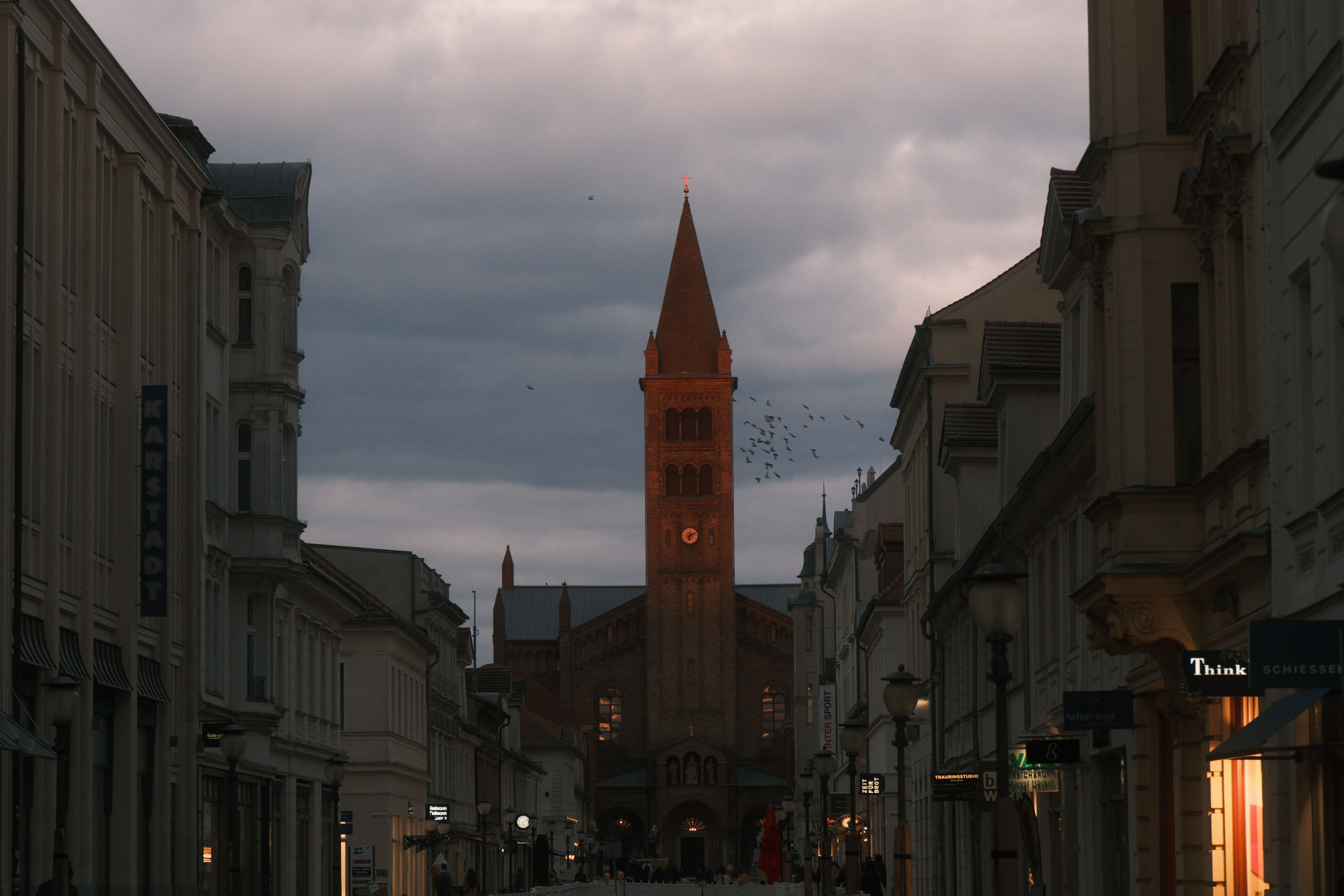 Kirchturm mit historischer Uhr in deutscher Altstadt bei Sonnenuntergang