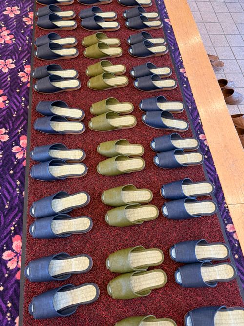 Free Row of neatly arranged slippers on colorful carpet indoors. Stock Photo