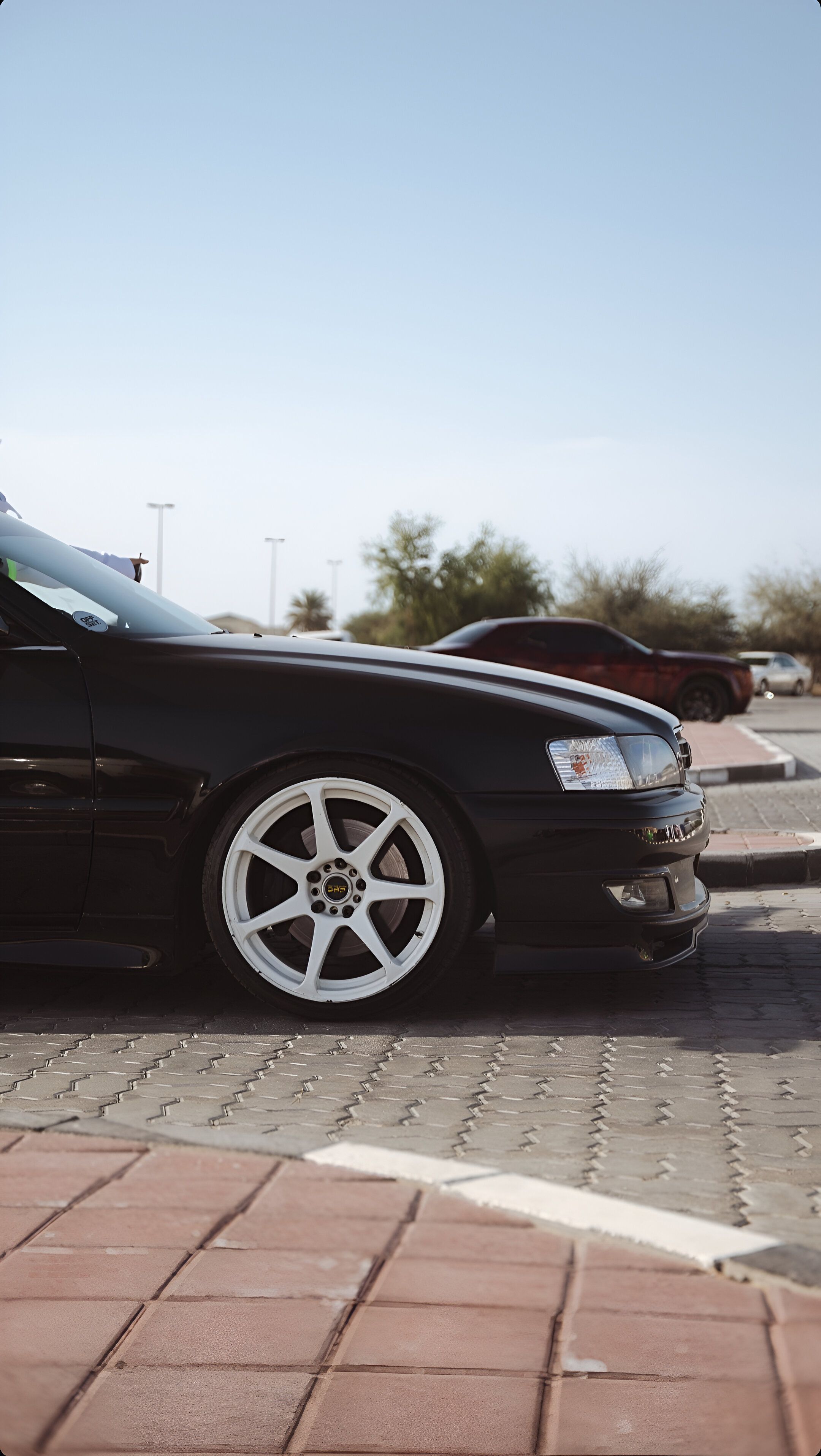 A sleek black Toyota at a car meet in Dubai showcasing its design in the sunlight.