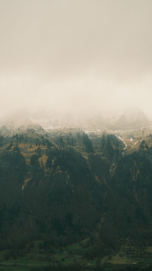 Free A serene mountain landscape with fog rolling over the peaks, creating a mystical atmosphere. Stock Photo