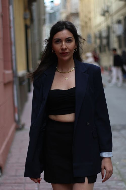 Free Portrait of a fashionable woman in a blazer walking down an Istanbul street. Stock Photo