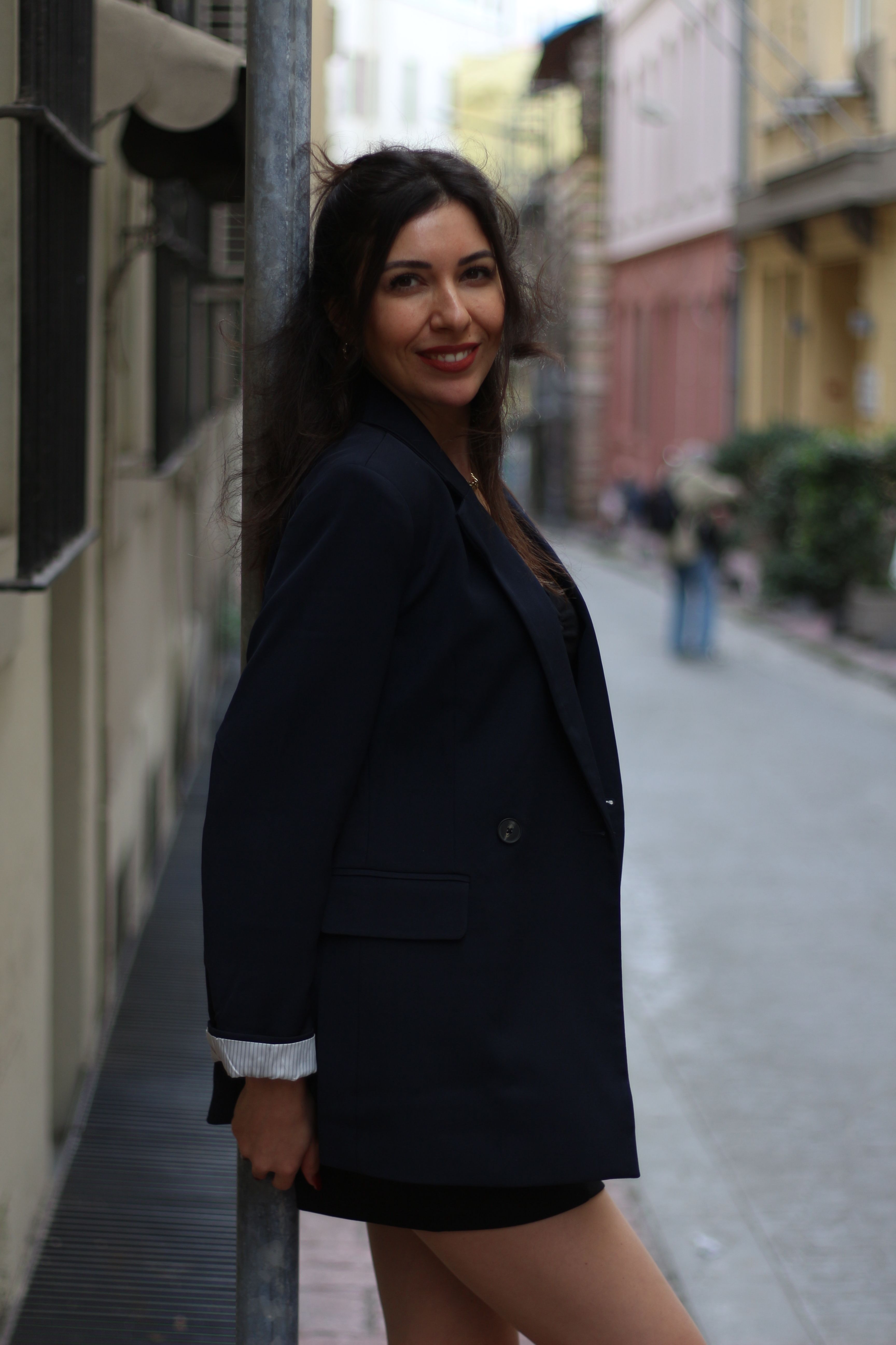 Stylish woman posing elegantly in a historic Istanbul street setting.