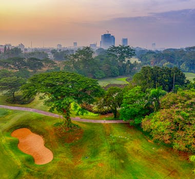 Scenic aerial shot of a lush golf course surrounded by greenery in Banten, Indonesia.