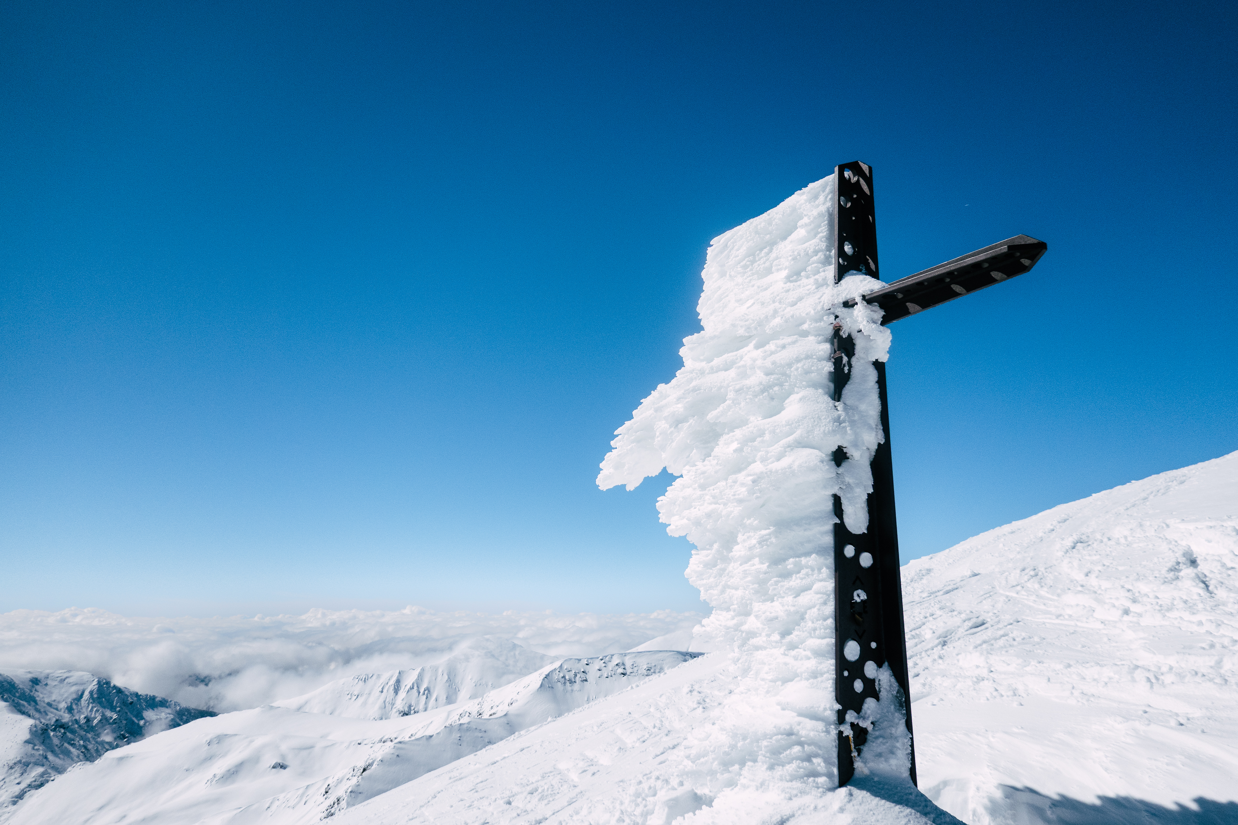 Snow-Covered Cross on Mountain with Blue Sky · Free Stock Photo