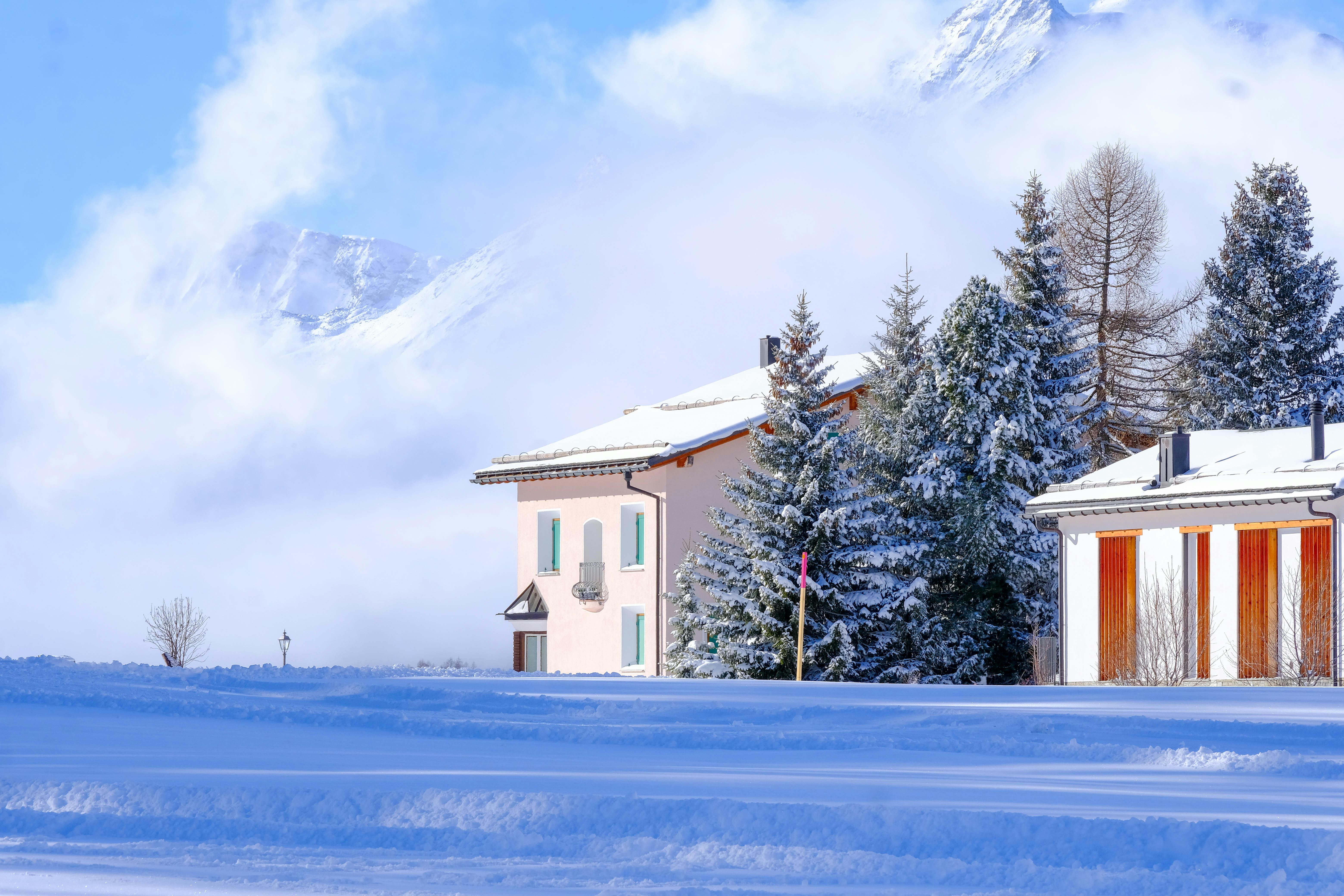 Scène enneigée paisible d'une cabane alpine entourée d'un paysage hivernal et d'une vue sur la montagne.
