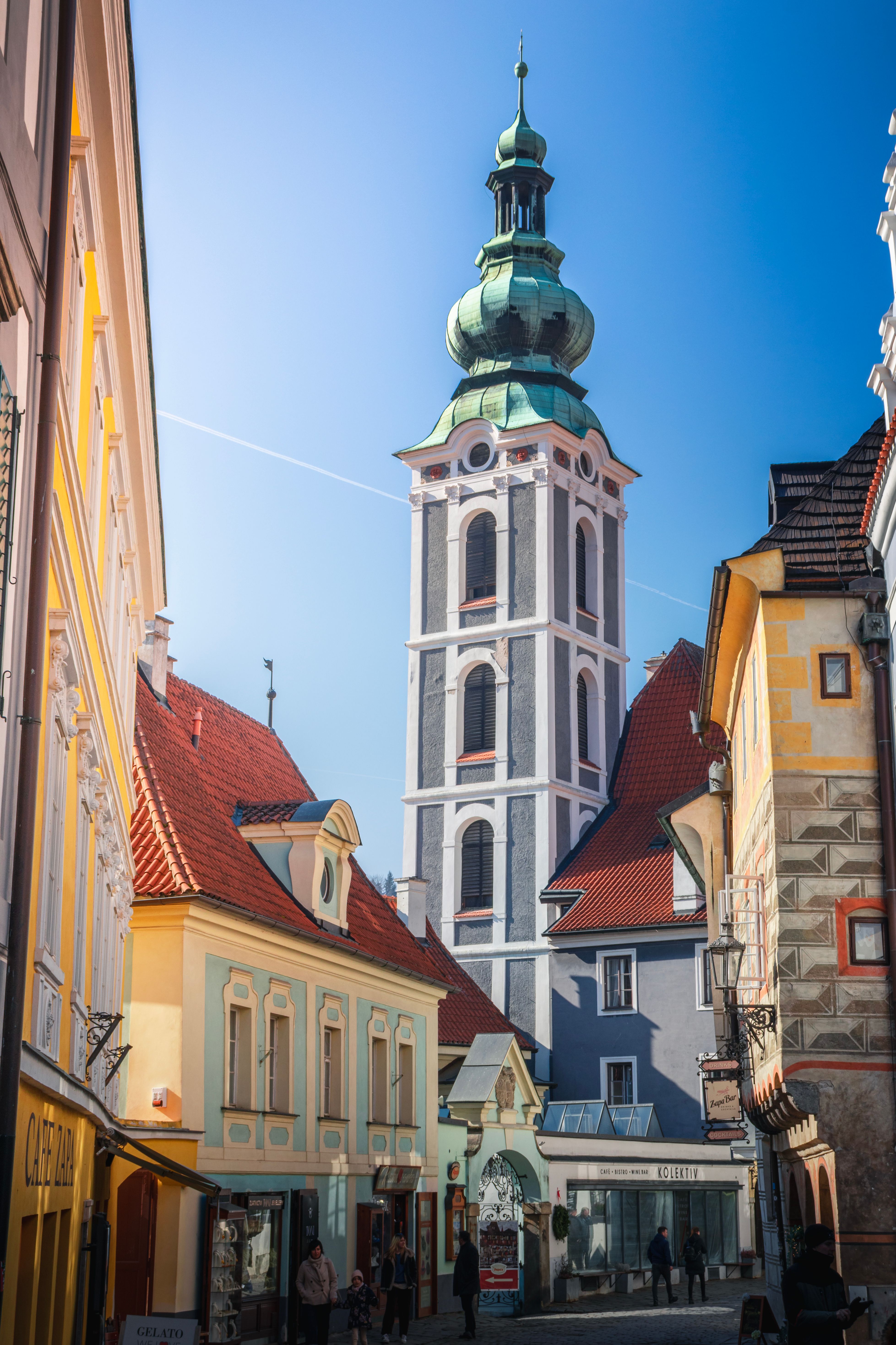 Colorful architecture in Český Krumlov with a prominent baroque church tower.