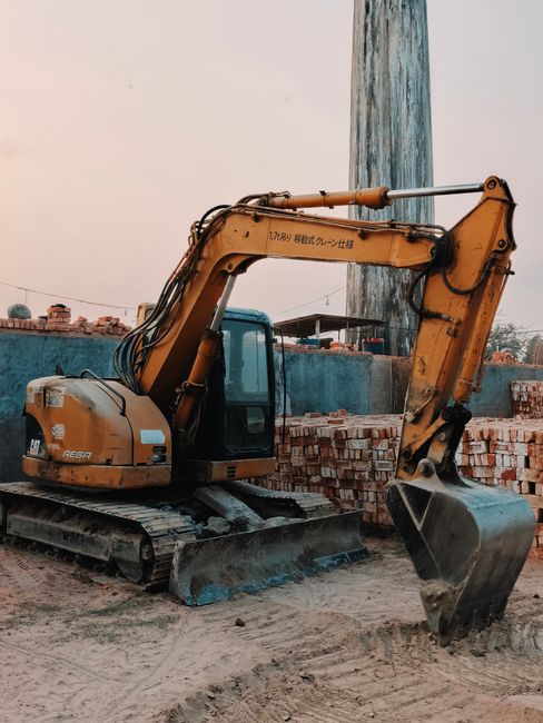 A mid-size excavator on a job site demonstrating the utility of various excavator attachments.