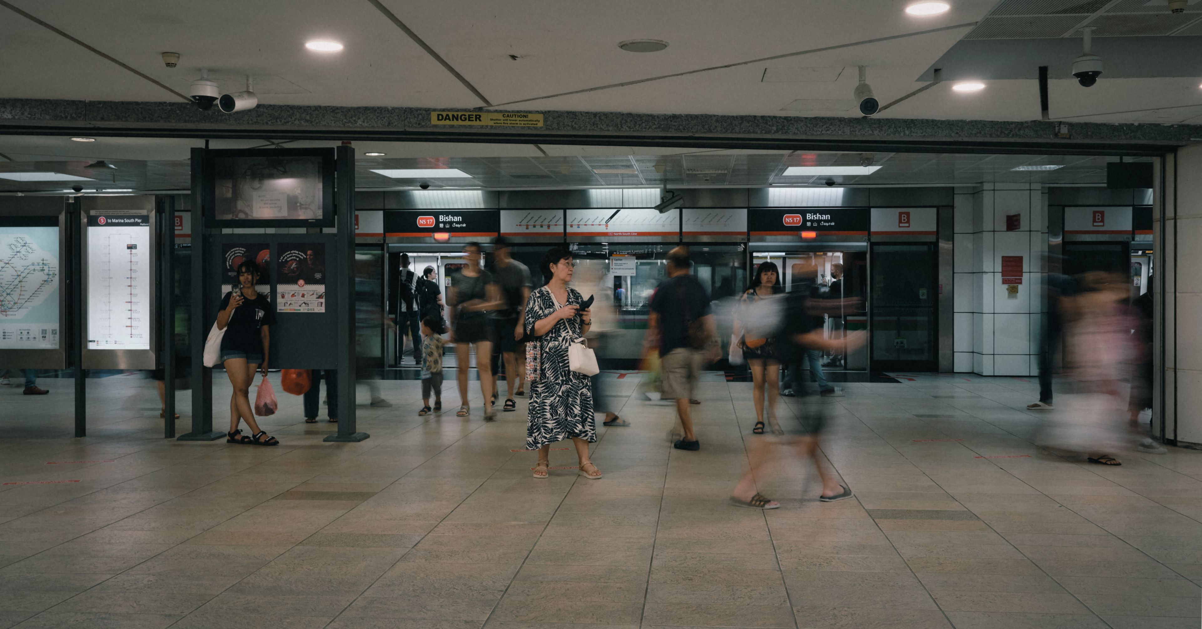 Family with a stroller using a covered walkway near an MRT station in Singapore