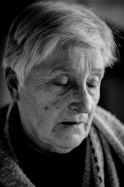 Free Close-up black and white portrait of a senior woman with eyes closed, conveying emotion and depth. Stock Photo
