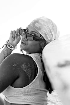 Stylish woman with sunglasses at the beach in a black and white portrait.