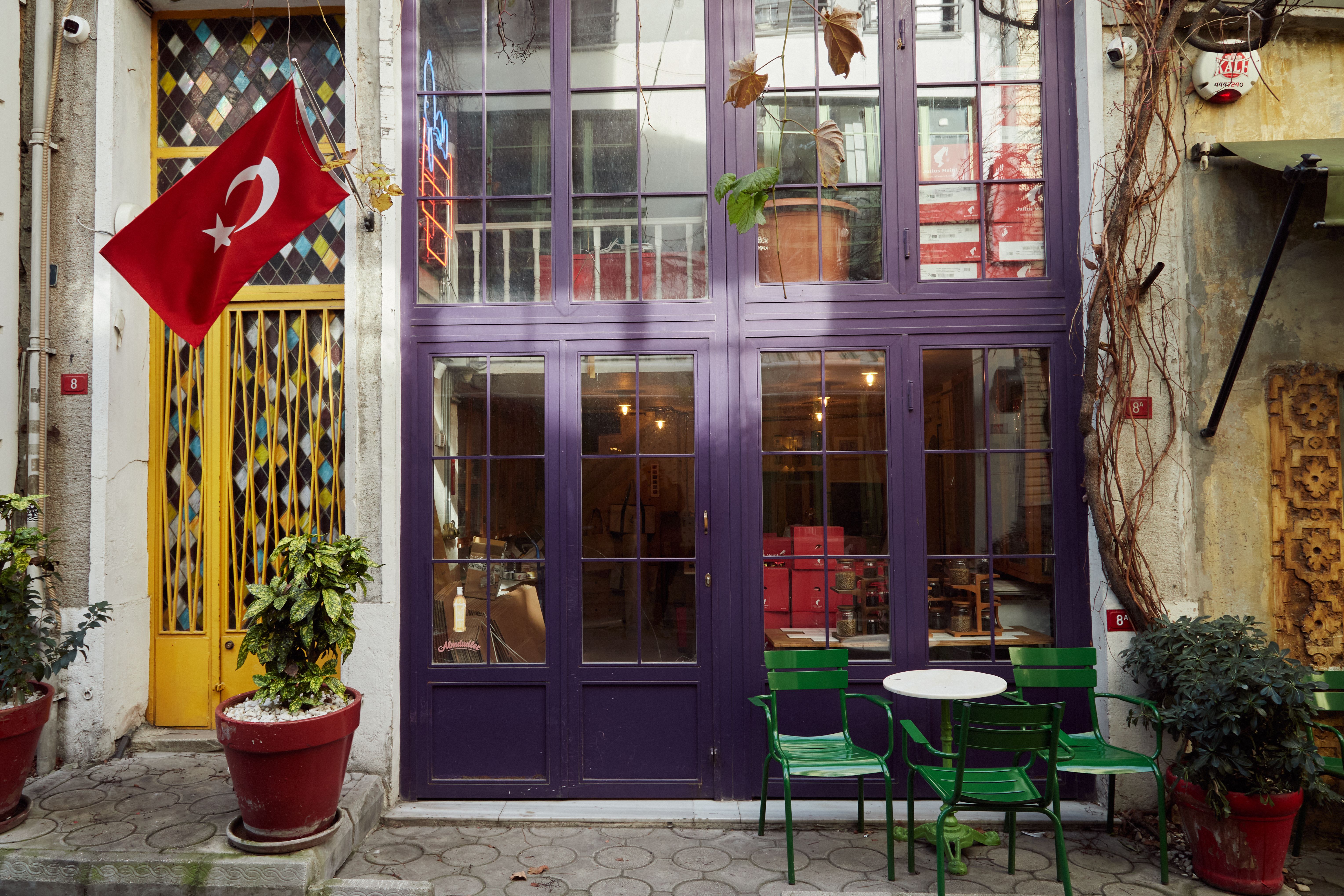 Cozy Istanbul street cafe with a Turkish flag, vibrant colors, and classic architecture.