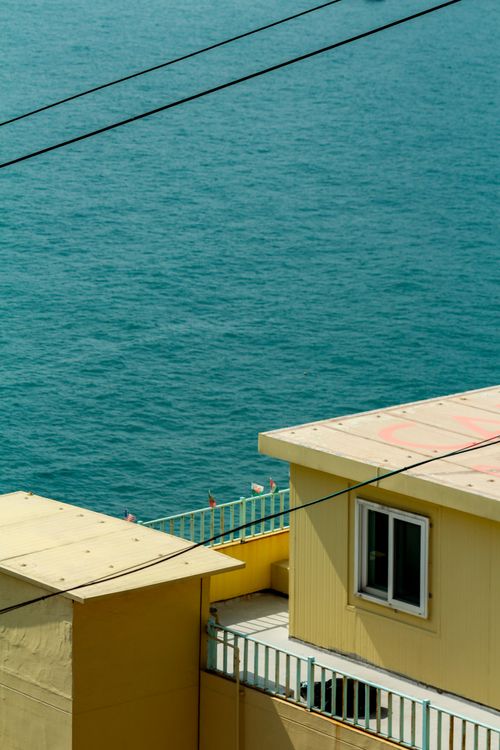 Free Yellow buildings overlooking the ocean in Busan, South Korea, showcasing a peaceful coastal scene. Stock Photo