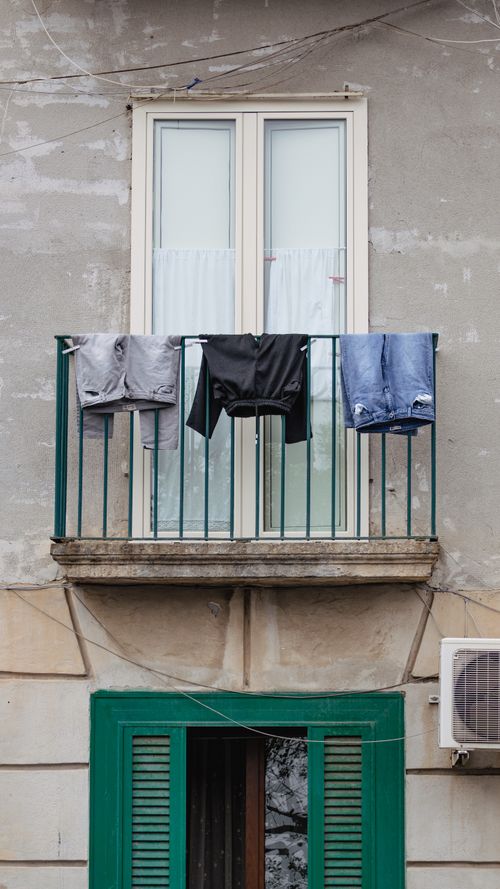 Free A vintage Italian balcony with clothes drying, capturing authentic lifestyle and architecture. Stock Photo