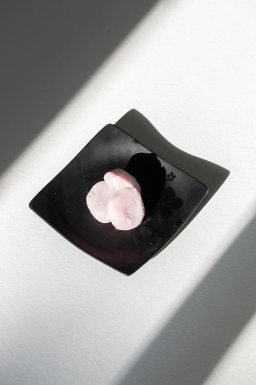 Free Stylish presentation of pink mochi on a black plate with dramatic shadows in daylight. Stock Photo