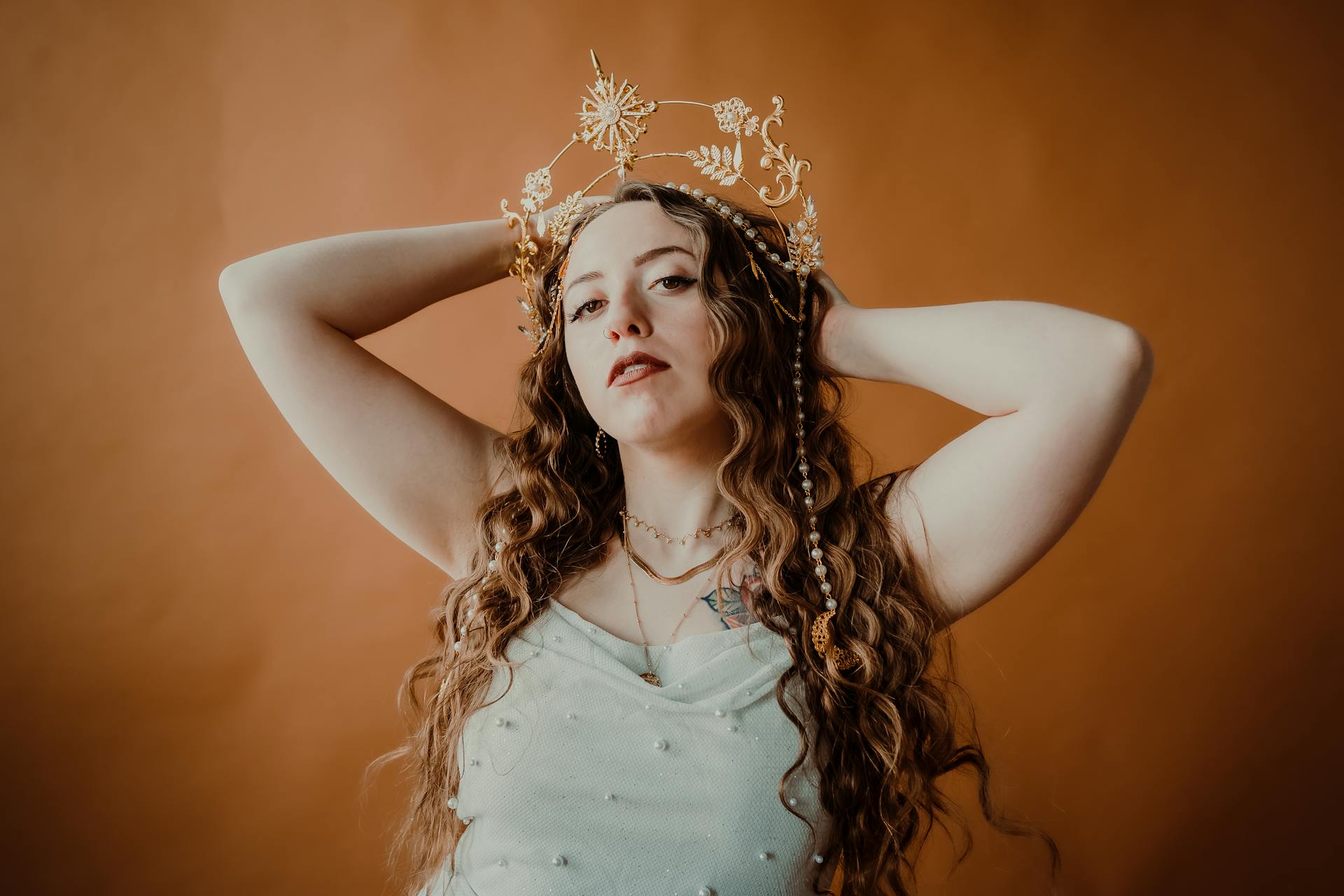 Portrait of a woman in a golden crown and white dress conveying elegance and grace.