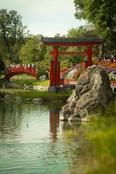 Explore the tranquil beauty of Buenos Aires' Japanese Garden featuring vibrant flowers and a picturesque red bridge.