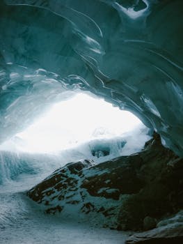 Explore the captivating textures of a serene ice cave lit by natural daylight.