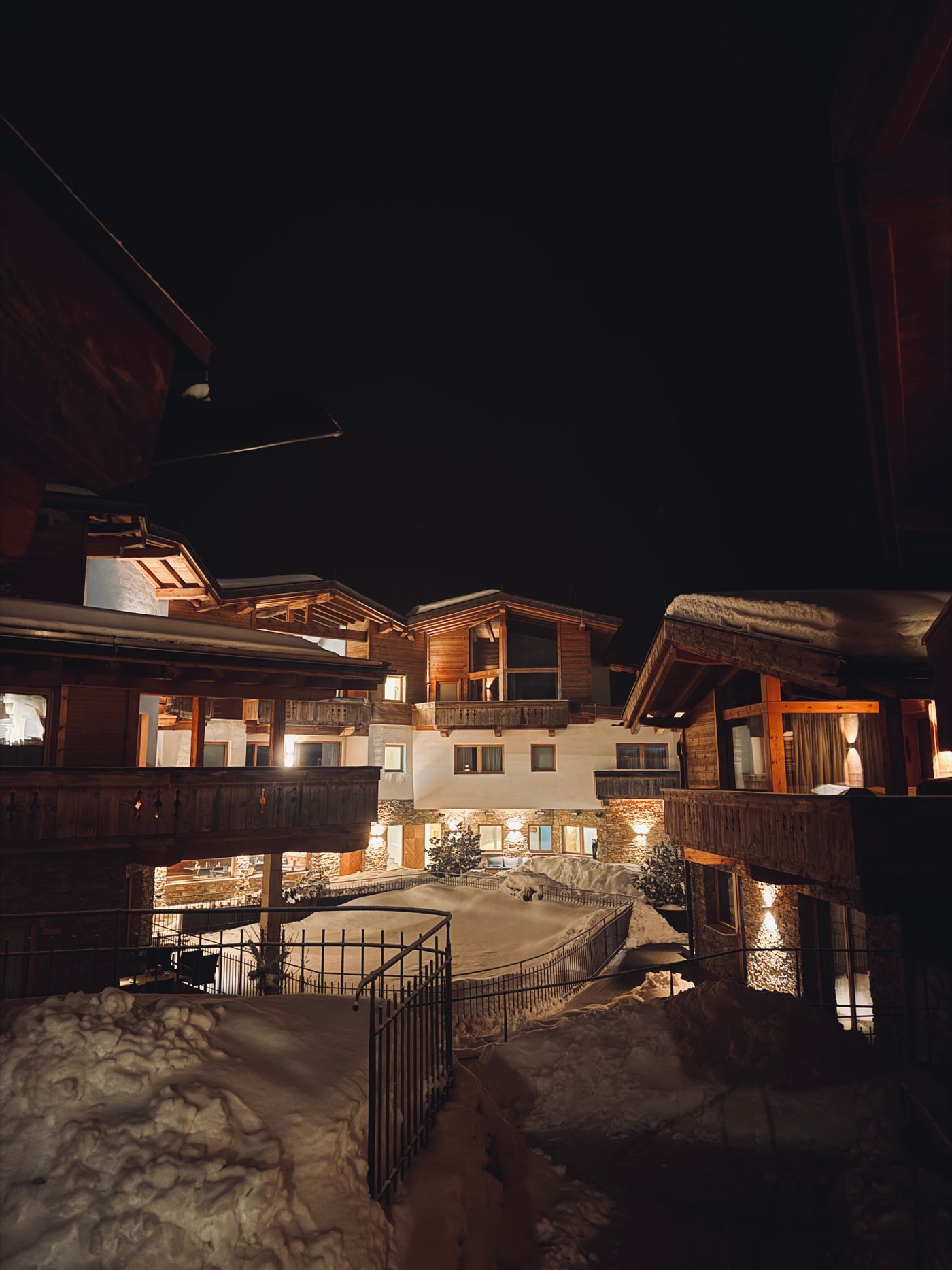 Warmly lit alpine chalet at night in the snow