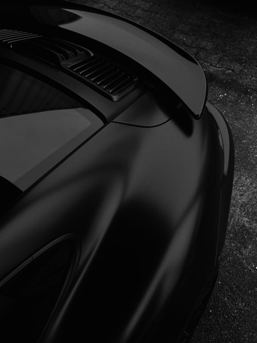 Free Sleek black high-performance sports car close-up, featuring aerodynamic design. Stock Photo