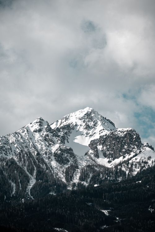 Free Majestic snow-covered mountain peaks under cloudy skies, capturing the essence of winter. Stock Photo