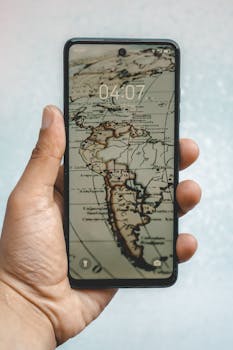 Person holding a smartphone displaying a vintage map of South America, emphasizing global connectivity.