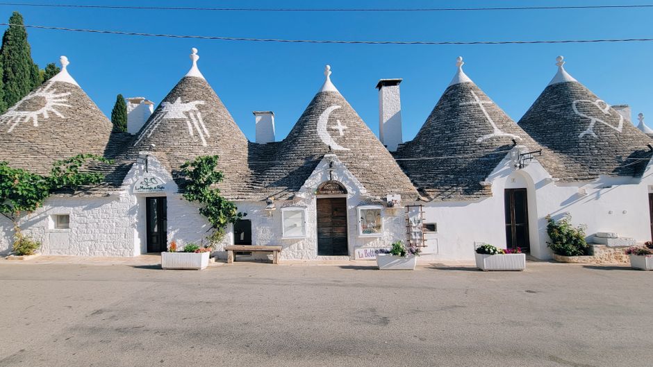 Trulli houses with conical roofs in Alberobello, Italy, on a sunny day.