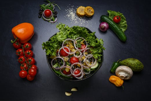 Top view of a fresh vegetable salad surrounded by various colorful ingredients.