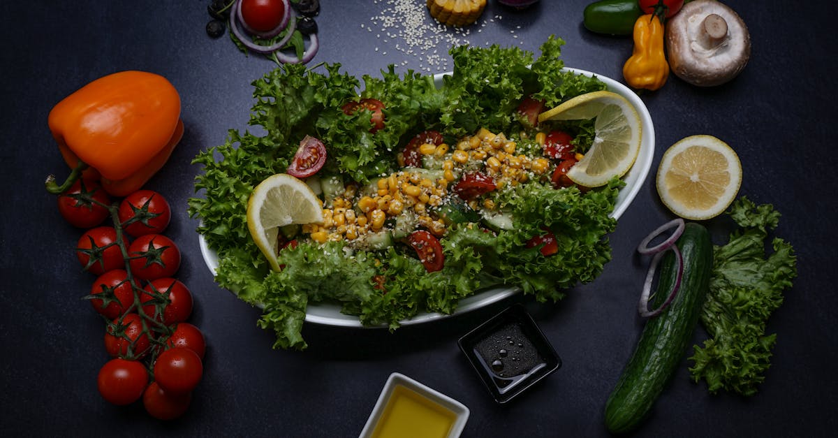 Healthy fresh salad surrounded by colorful vegetables and condiments on a dark background, perfect for food lovers.