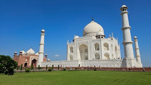 Free Stunning view of the Taj Mahal, showcasing its iconic architecture under a bright blue sky. Stock Photo