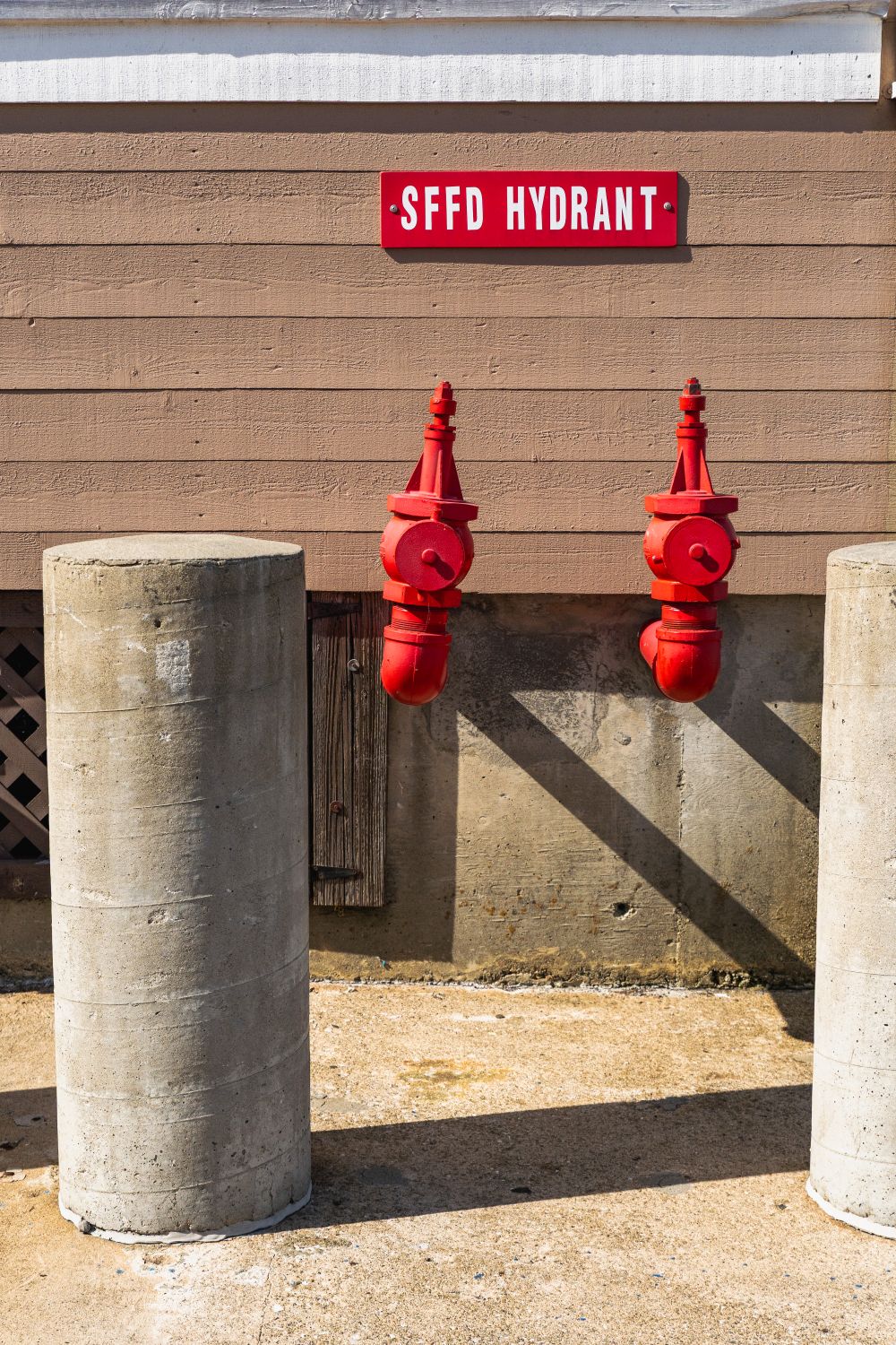 Dual Red Fire Hydrants on Urban Wall Setup · Free Stock Photo