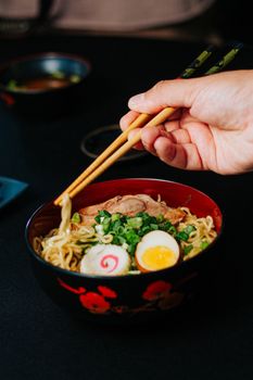 Delicious ramen bowl garnished with traditional toppings and served with chopsticks for a genuine Japanese dining experience.