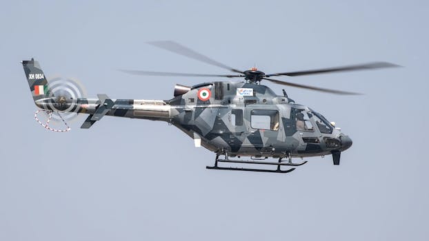 A military helicopter flies at an airshow in Bengaluru, showcasing advanced technology.