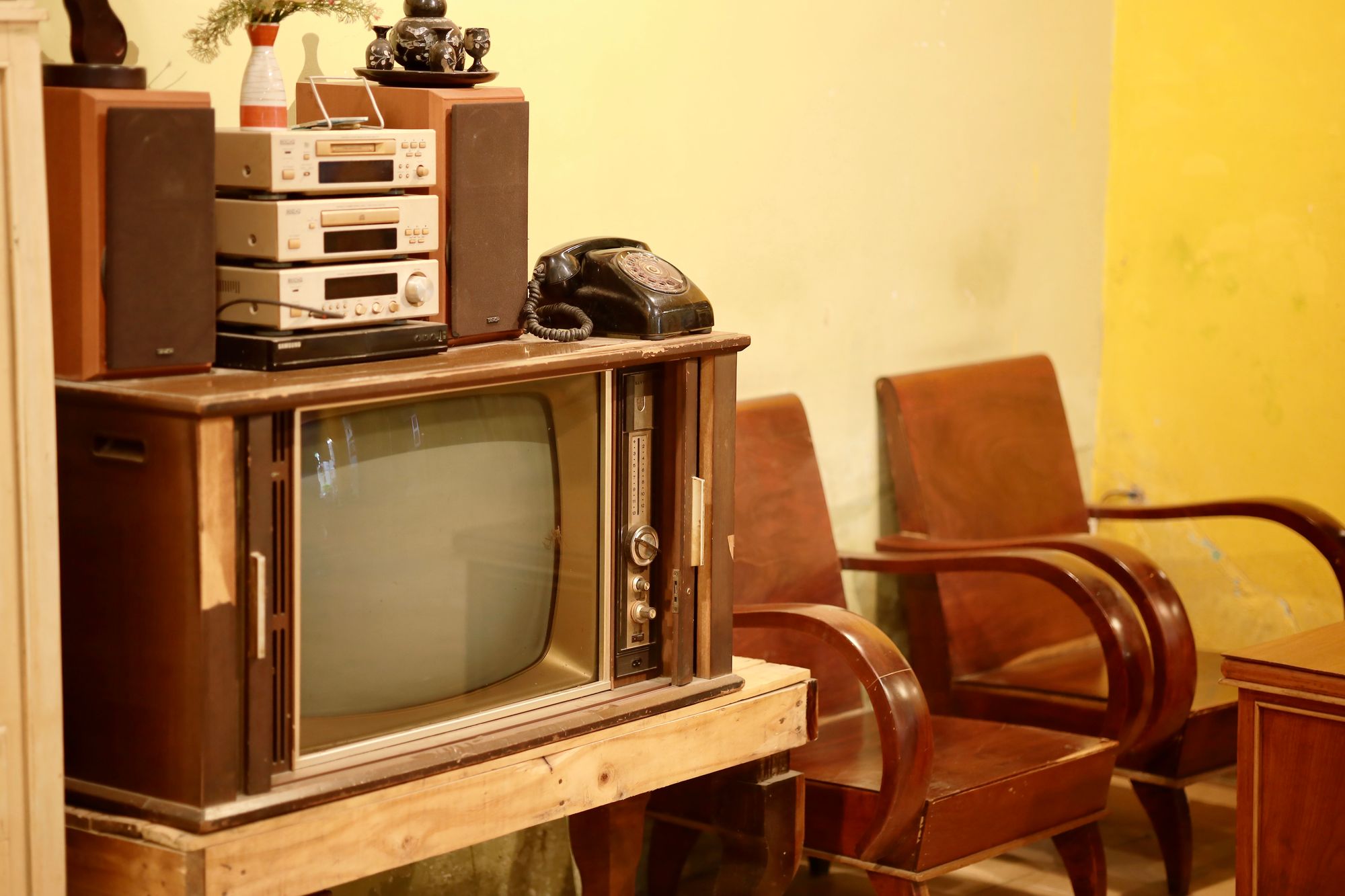 Televisor antiguo encendido sobre un mueble de madera en el salón de una casa
