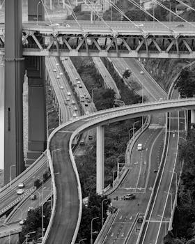 Dynamic aerial view of a highway interchange captured in monochrome, showcasing urban infrastructure.