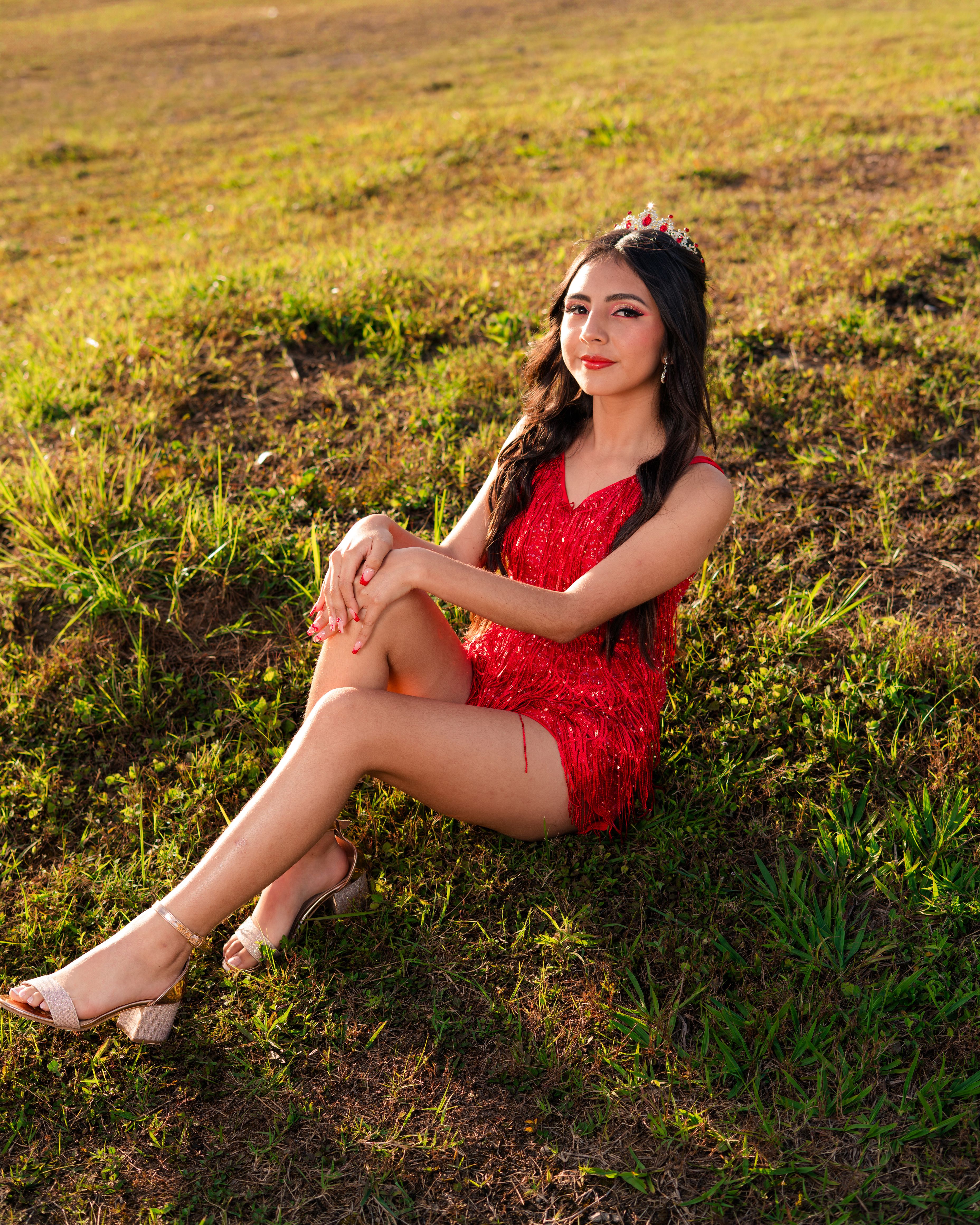 Young woman in red dress sitting on grassy field · Free Stock Photo