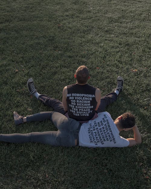 Free Two Men Sitting and Lying on Grass Stock Photo