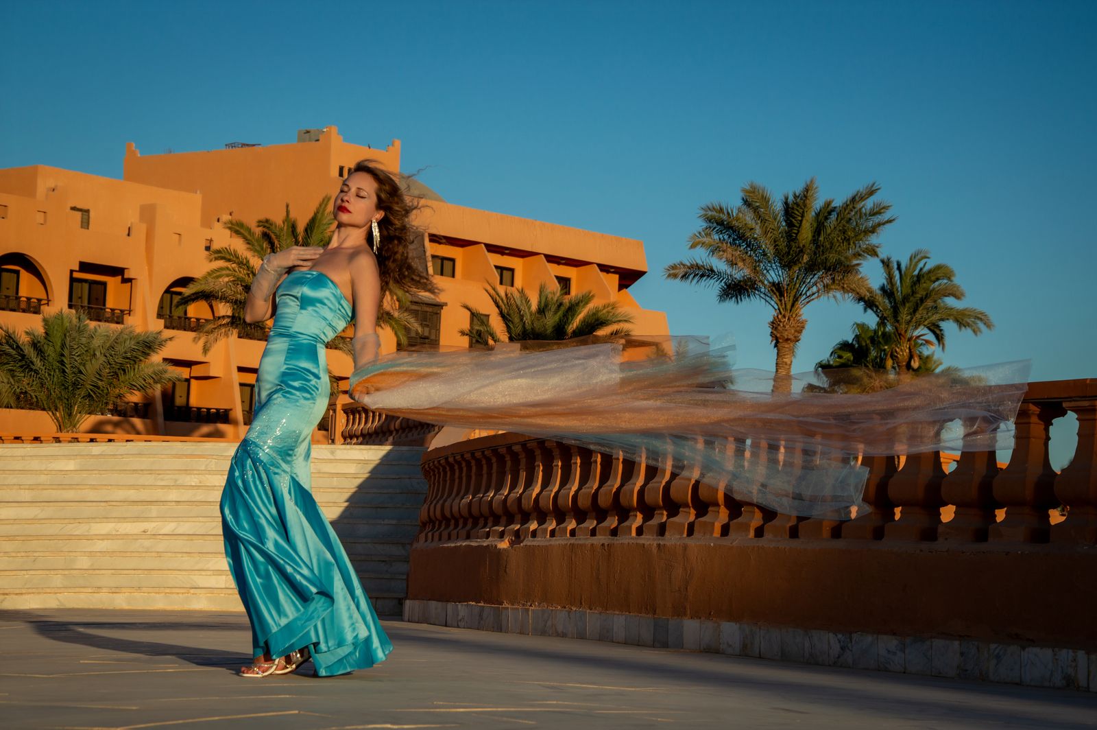 Woman wearing a flowing blue gown at an elegant tropical resort