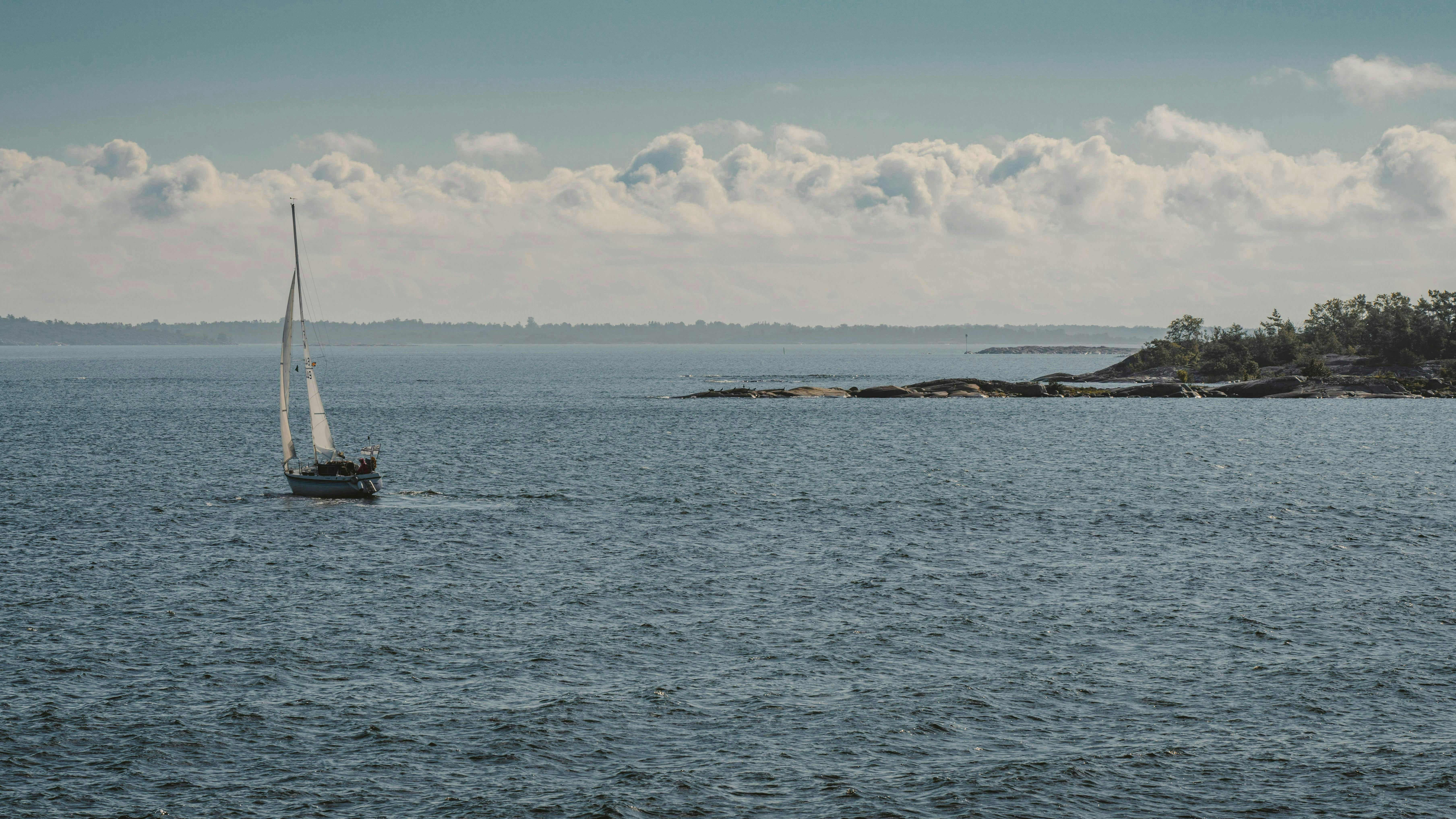 Gratis Vista panoramica di una barca a vela che naviga nelle acque tranquille dell'arcipelago finlandese. Foto a disposizione
