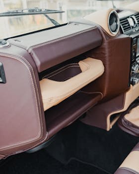 Elegant luxury car dashboard featuring brown and beige leather accents, showcasing premium interior design.