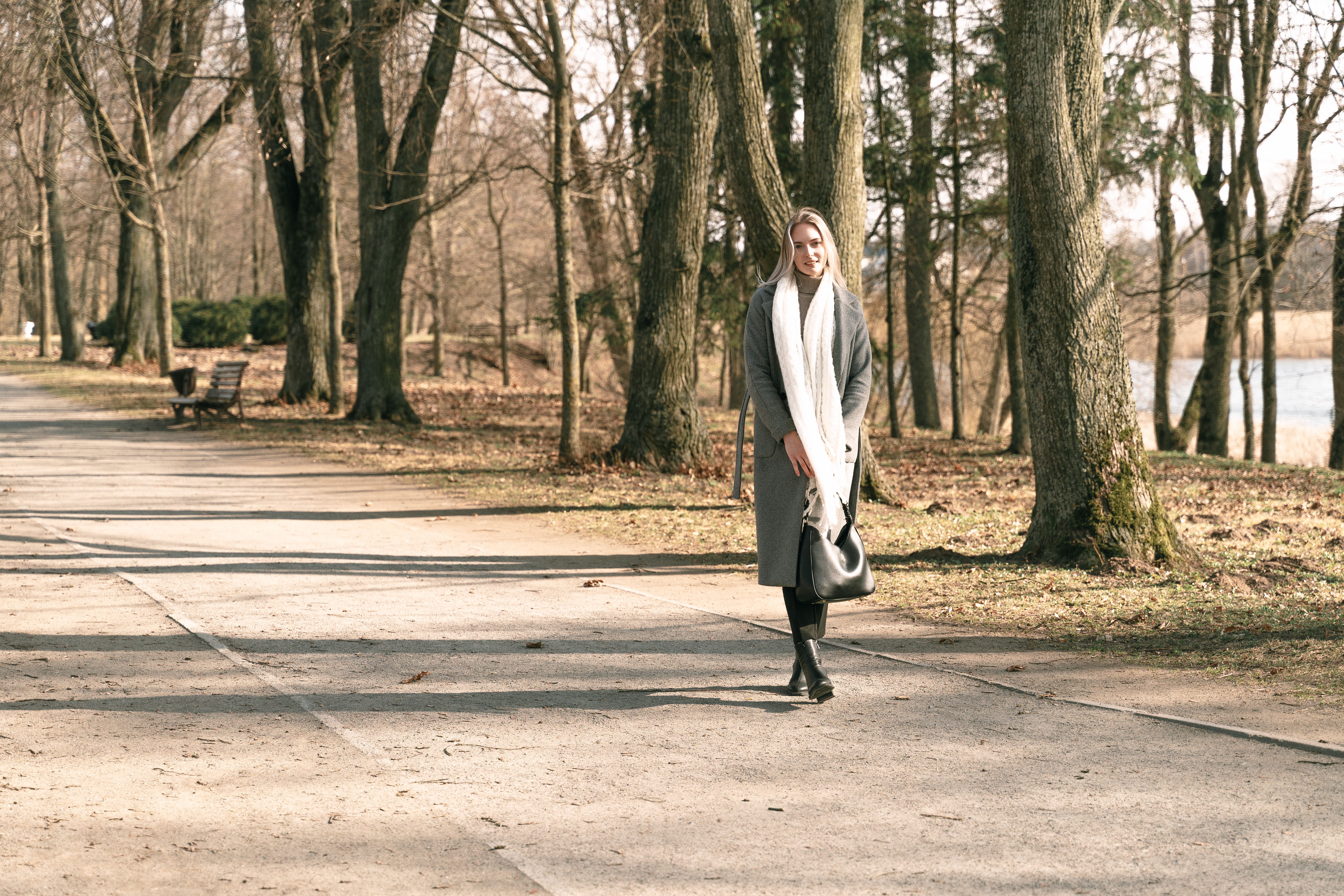 Woman Walking in Tranquil Winter Park Pathway · Free Stock Photo