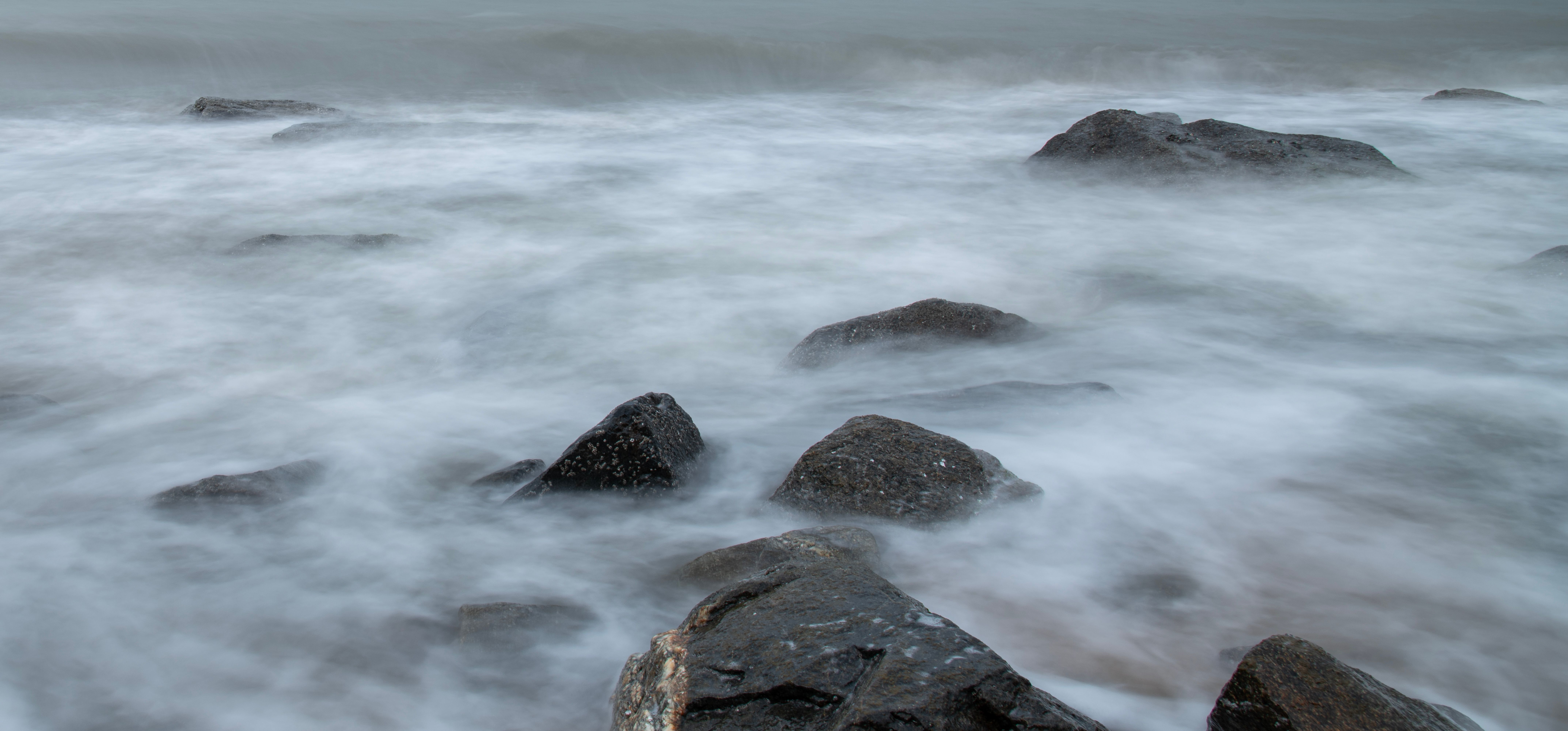 Serene Coastal Rocks Surrounded by Gentle Waves · Free Stock Photo