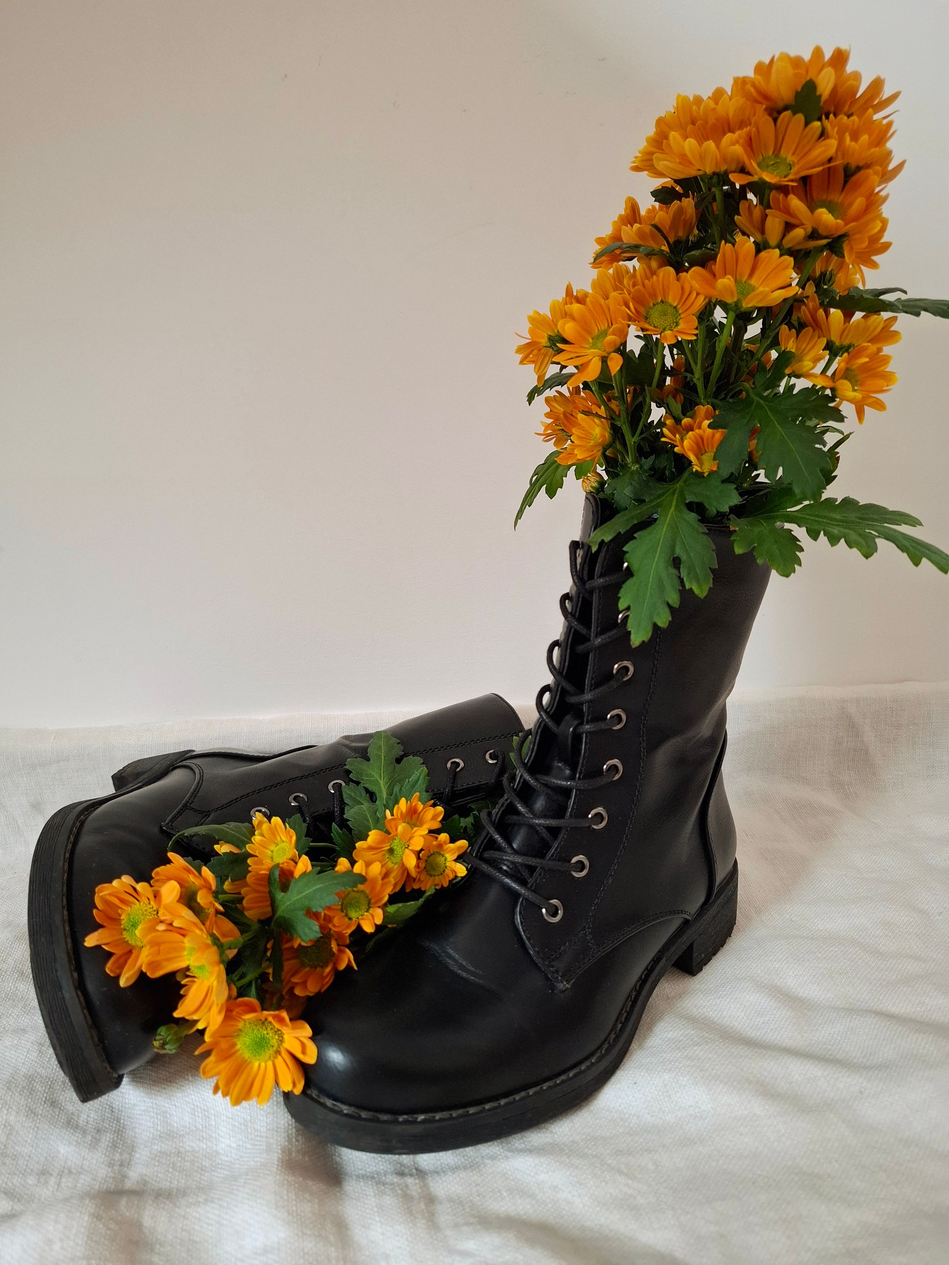 Chic Black Boots with Vibrant Flowers · Free Stock Photo